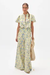 Pantalón de lino con estampado floral en tonos amarillos y azules, de corte palazzo y tiro alto.