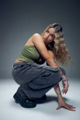 Jean baggy de tiro bajo, color negro, con dos grandes bolsillos de solapa y tiras con hebillas metálicas, además de un bordado de rayo.