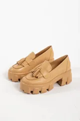 Mocasines negros de cuero con suela track y detalle de borlas.