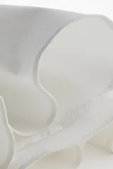 Vestido corto blanco con escote en V profundo, mangas largas con abertura en los puños, cierre oculto en la espalda y cinturón fino extraíble.