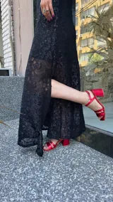 Vestido largo de encaje negro con lurex, cuello halter y tajos laterales. Incluye un vestido corto removible como forro.