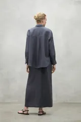 Camisa blanca de lino con corte clásico, cuello camisero y mangas largas.