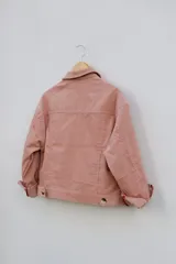 Campera de pana color rosa con botones dorados, cuello clásico y bolsillos con solapa en el pecho.