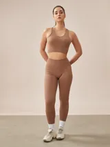 Top deportivo gris oscuro con espalda deportiva y banda elástica en el bajo busto.