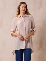 Camisa color beige claro, de corte recto y mangas 3/4 con botón para sujetar.