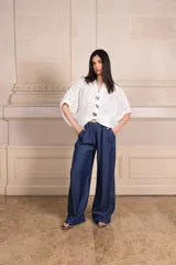 Camisa blanca calada con botones y mangas cortas. Incluye tres prendedores con forma de flor.