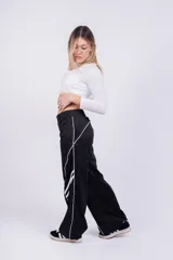 Pantalón deportivo rojo con detalles de líneas blancas curvas en los laterales.
