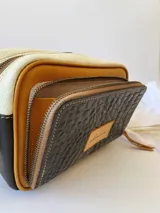 Bandolera rectangular combinada en color negro, beige y blanco, con correa larga regulable y bolsillo exterior con cierre.