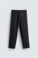 Pantalón de vestir negro de corte relaxed fit confeccionado en tejido con lana. Cuenta con bolsillos frontales y traseros de doble vivo con botón. Cierre frontal con cremallera y botón.