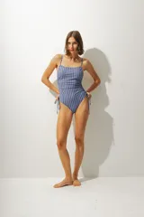 Malla enteriza con estampado a rayas verticales azules y negras, breteles finos y laterales con cordones ajustables.