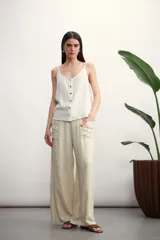 Pantalón negro de corte palazzo, con cintura alta con cordón ajustable y bolsillos laterales.