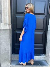 Vestido largo azul eléctrico con escote en V, mangas cortas con detalle de lazo y falda con volantes.