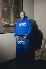 Pantalón azul de felpa de algodón con corte oversize y doble cintura simulando boxer. Estampa de perro blanco en el muslo.