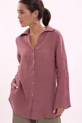 Camisa de manga larga, color rosa viejo, con cuello camisero y botones frontales. Presenta un calce holgado.