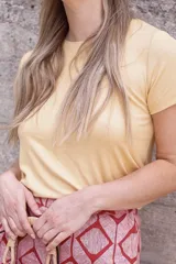 Remera color amarillo de viscosa, con cuello redondo y mangas cortas.
