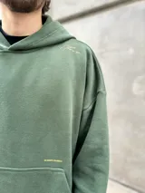Hoodie verde militar de felpa con frisa gruesa, corte boxy, estampado dorado en la espalda con la frase "BURN THE SHIPS" y terminaciones de calidad superior.