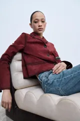 Blazer color borgoña confeccionado en piel de ante. Tiene cuello solapa de muescas, manga larga, bolsillos de vivo en delantero, forro interior y cierre frontal con botones.
