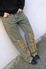 Pantalón de jean celeste con lavado gastado y roturas en las rodillas, de corte recto y tiro bajo.