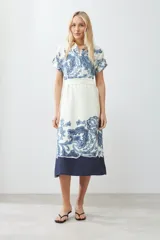 Vestido midi color blanco con estampado de paisley en azul y cinturón de lazo.