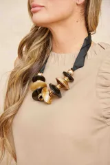 Blusa color beige, sin mangas y con cuello redondo con volados.
