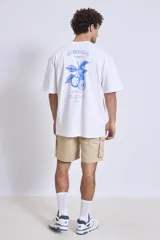 Remera blanca de corte holgado con pequeño estampado en el pecho.