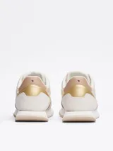 Zapatillas Tommy Hilfiger color crema con detalles en beige y dorado. Confeccionadas en poliéster con paneles mixtos y logo bordado en la lengüeta y el talón.