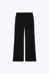 Pantalón negro de tiro alto con bolsillos delanteros, pinzas delanteras y cierre frontal con cremallera y ganchos metálicos.