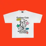 Remera blanca de algodón con corte boxy y estampado con el logo de Gurises Club, que incluye un personaje de caricatura, estrellas, un dado y la inscripción 'Montevideo Cool Kids'.