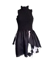 Vestido corto color beige, confeccionado en lino con tiras de cuero vacuno. Presenta elástico en la parte superior y falda irregular en lino y cuero.