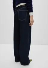 Pantalón de jean azul oscuro, corte wide leg, tiro alto, con cinco bolsillos, trabillas y cierre frontal con cremallera y botón.