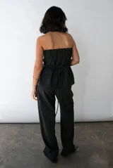 Mono strapless negro con corte en A y lazo en la cintura.