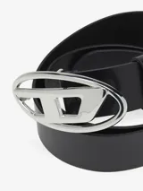 Cinturón de cuero negro con hebilla grande ovalada plateada que presenta el logotipo 'D' de la marca.
