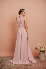 Mono de fiesta color rosa pálido, con cuello halter, cuerpo drapeado con lentejuelas y pantalón palazzo. Incluye cinturón con lentejuelas.