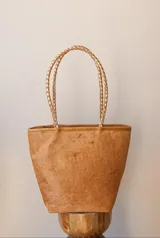Cartera tipo tote bag color marrón con textura de pelo, forrada por dentro y con detalles de piedras. Tiene doble asa de mano trenzada color dorado.