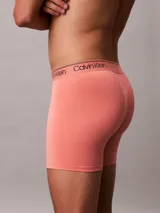 Pack de tres bóxer brief Calvin Klein, confeccionados en mezcla de poliéster y elastano. Incluyen cintura elástica con el logo distintivo de la marca. El pack incluye un bóxer rojo liso, uno rosa liso y uno gris a rayas horizontales.