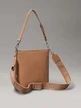 Cartera tipo saco color tostado de cuero sintético granulado, con correa de hombro ajustable de cuero sintético y correa bandolera ajustable de jacquard con logo.