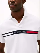Chomba blanca de manga corta con cuello polo y tapeta de dos botones. Diseño con corte regular y logo de Tommy Hilfiger bordado en el pecho.