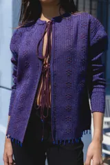 Cárdigan tejido con lurex y mostacillas, con escote en V y cierre frontal con lazo.