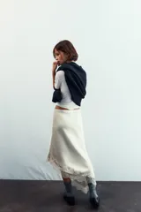 Falda color crema de satén con corte al bies y terminación asimétrica con encaje.