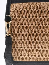 Monedero tipo sobre de paja trenzada color arena con forro negro y tira de agarre.