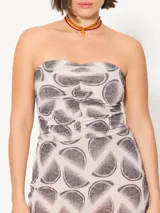 Vestido strapless confeccionado en mesh estampado con motivos geométricos color marrón sobre fondo verde lima. Lleva frunces en el delantero y cierre metálico niquelado en la espalda. Su largo llega por debajo de la rodilla.