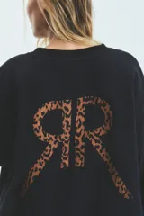 Buzo oversize de frisa esmerilada color negro, con cuello alto y estampa de leopardo en la espalda, con bolsillos laterales.