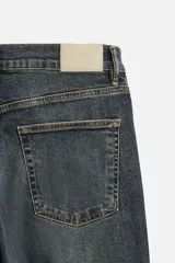 Pantalón de jean azul oscuro, corte slim fit, tiro medio, cinco bolsillos, tejido elástico y efecto lavado.