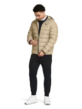 Campera inflada color beige con capucha, cierre frontal completo y logo de Under Armour bordado en el pecho.
