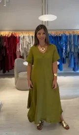 Vestido largo color verde oliva, de corte acampanado, con escote en V y mangas cortas.