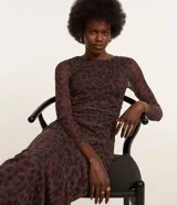Vestido midi ajustado de tule color marrón con estampado de leopardo negro, cuello redondo y mangas largas transparentes.