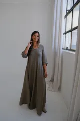 Vestido largo color visón, de corte acampanado y manga corta.