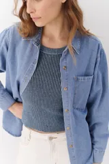 Camisa de jean celeste de manga larga con botones frontales y en los puños.