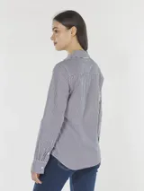 Camisa de manga larga con cuello inglés y corte regular, confeccionada en algodón orgánico con estampado de rayas verticales azules y blancas.