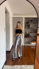 Pantalón acampanado con estampado de piel de víbora en blanco y negro, de tela rígida con elástico en la cintura.